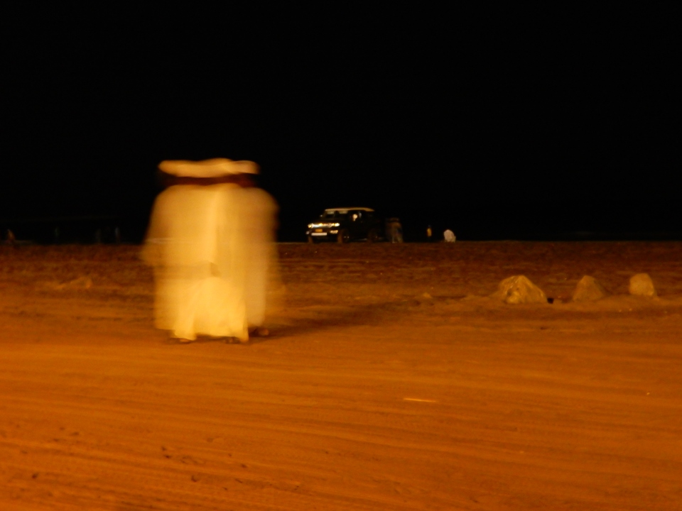 A blur of men on the beach.
